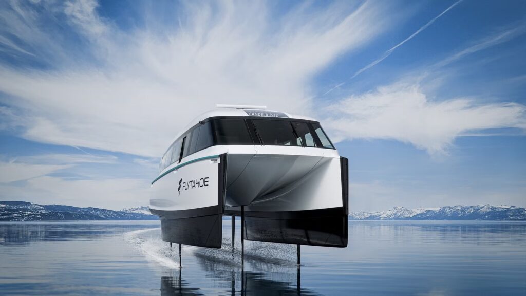 An all-electric Candela P-12 blue and white hydrofoil ferry cruising above the water on Lake Tahoe.