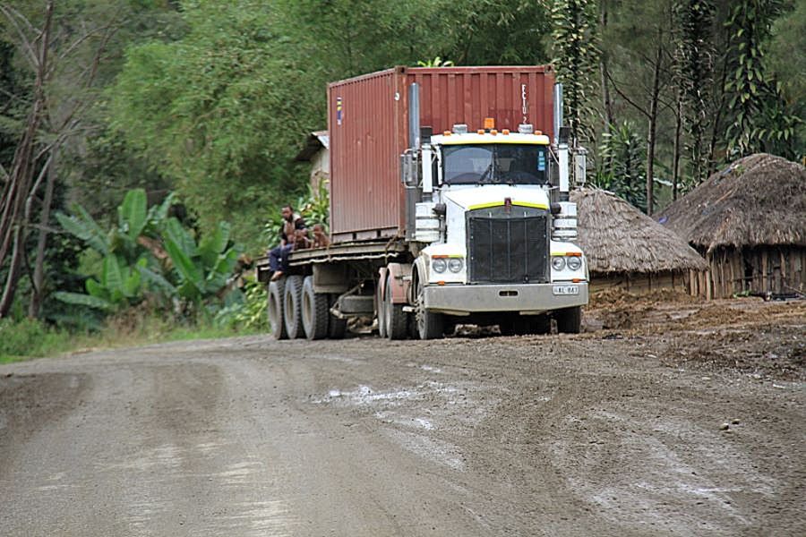 Red and white truck on unpaved rural low-volume road