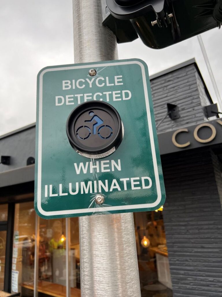 A road sign reads bicycle detected when illuminated. A bicycle symbol is shown in a round display on the sign.