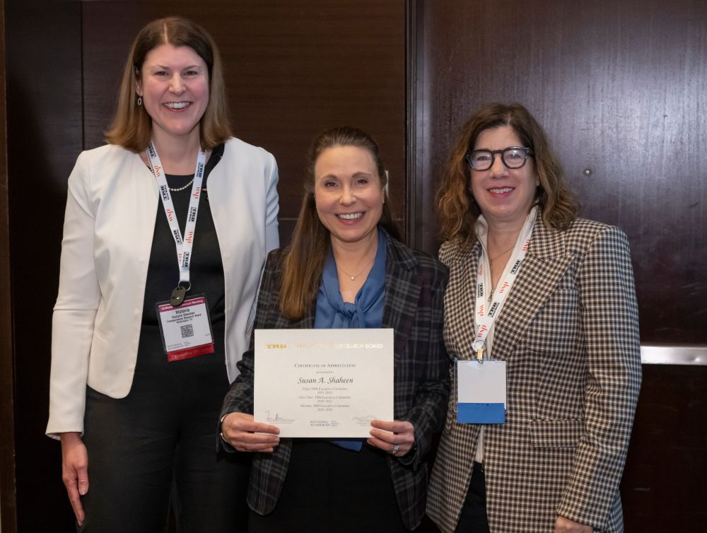 Victoria Sheehan, Susan Shaheen, and Leslie Richards stand together as Susan Shaheen holds a certificate.