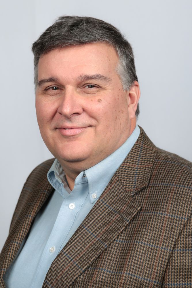 Donald A. Streeter, wearing a collared shirt and a jacket, faces forward and looks at the camera.