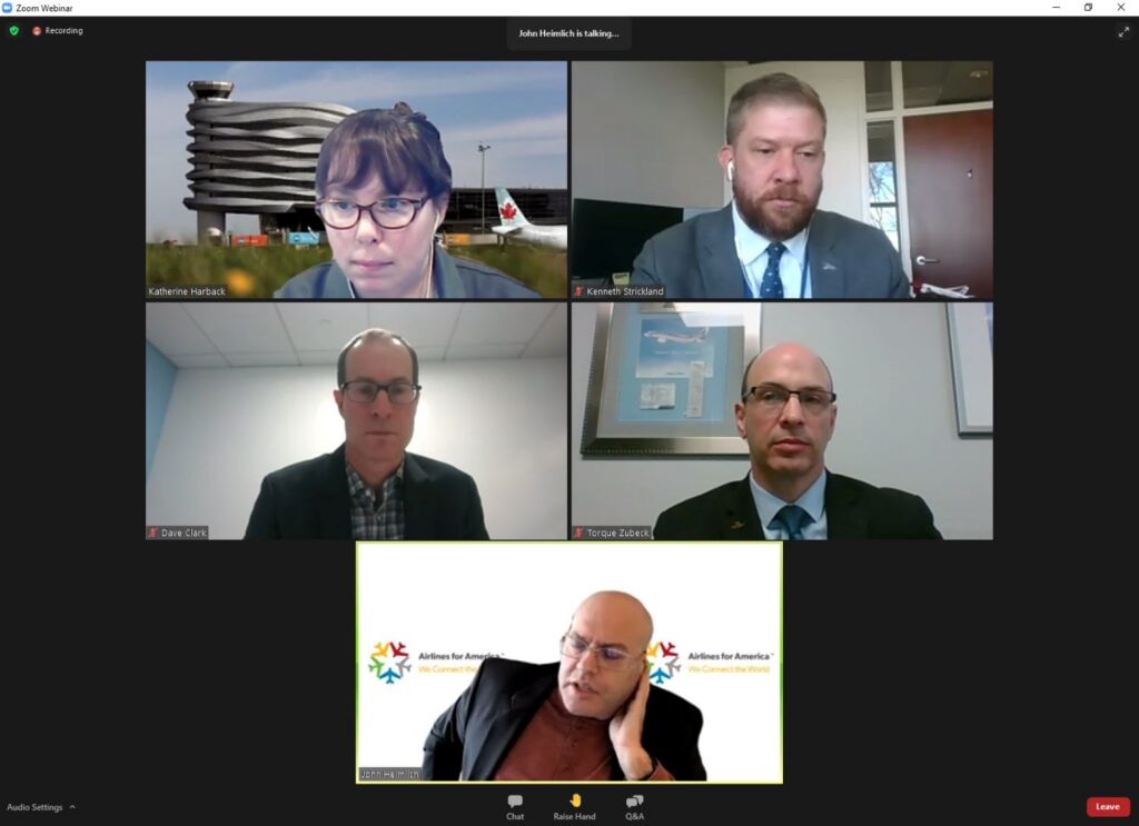 A Zoom webinar screen shows 5 participants in separate video windows during an online discussion.