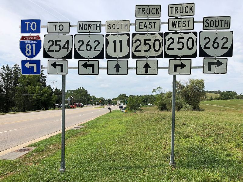 Road signs with arrows pointing right, left, and straight direct traffic to Interstate 81 and Routes 254, 262, 11, and 250. Route 250 east and west are truck routes.