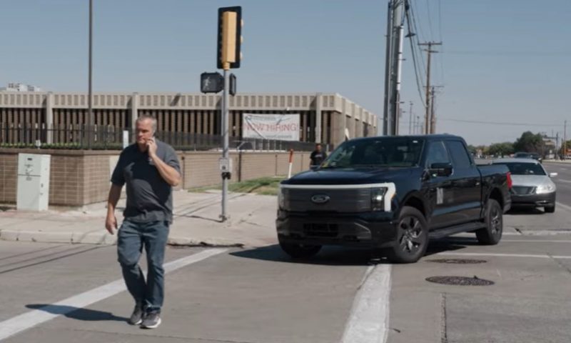 In a demonstration of Utah D O T's Connecting the West Program, a man walks through a crosswalk with pedestrian sensors on the traffic signal while a pickup truck safely turns into the intersection behind him.
