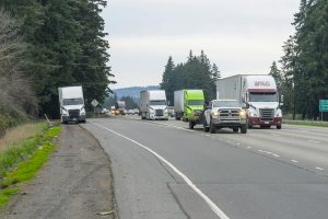 Frieght truck parked on a ramp shoulder of a busy interstate in Oregon.